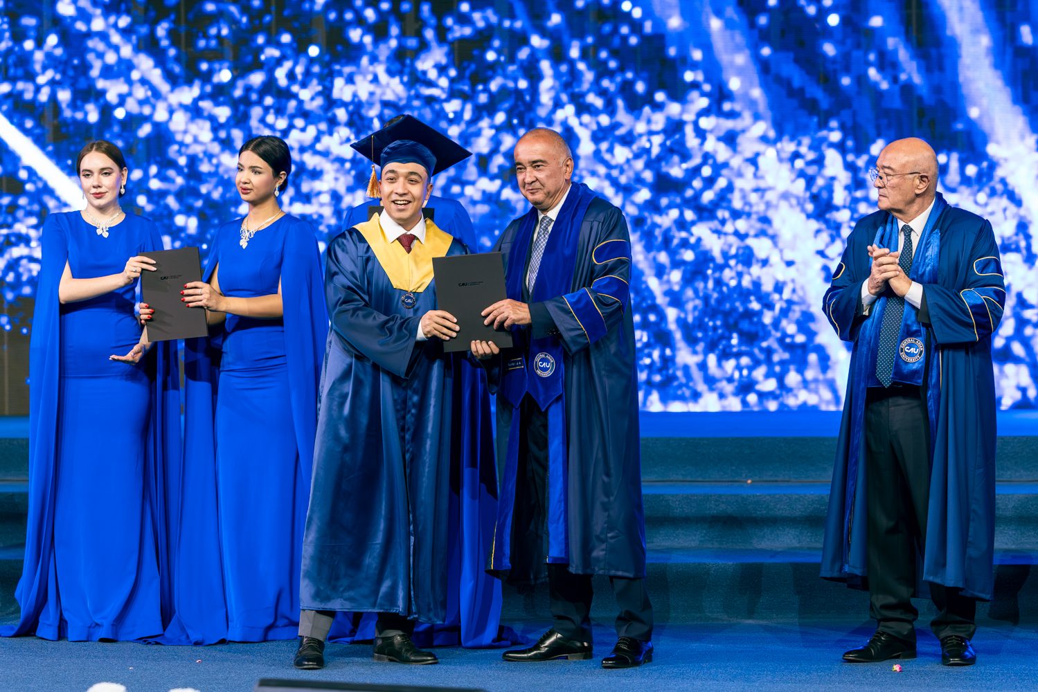 Asadbek Sultonov receiving his MD diploma on stage at the Central Asian University graduation ceremony