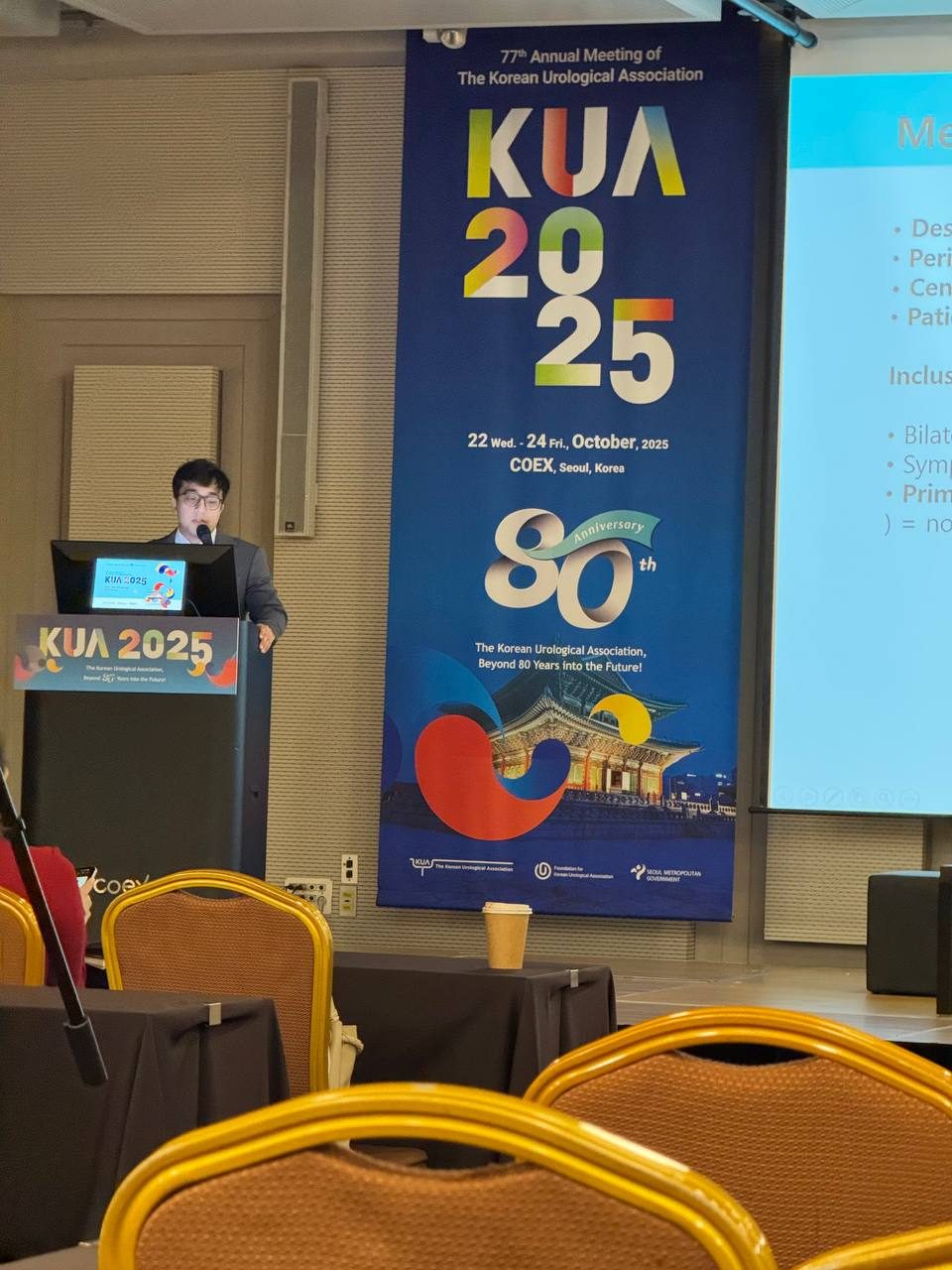 Asadbek Sultonov delivering an oral presentation at the podium at KUA 2025 in Seoul